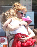 EXCLUSIVE Isla Fisher carries sleeping daughter's slipper in her mouth