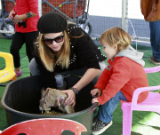 Selma Blair carries a fussy Arthur at the Farmers Market