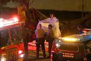 Coroners examine Paul Walker at the site of his Tragic Death