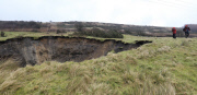 A field has disappeared into a giant sink hole at Foolow in The Derbyshire Peak District.  Locals claim the huge hole, measuring more than 160 ft across and 130 ft deep, which began collapsing yesterday and is still growing, was caused when part