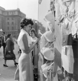 A young woman looking in the window of a lingerie shop in Piccadilly Circus, London, c1946-c1959.