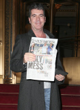 New Dad Simon Cowell Reading About His New Son In The Daily News 