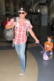Lance Armstrong carts his son Max on a suitcase before a flight at LAX