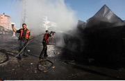 GAZA CITY : Palestinians inspect a destroyed bus after Israeli airstrikes in the central Gaza City.