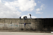 Palestinians climbing and smashing holes in the Israeli separation barrier at Abu Dis, Jerusalem, Israel - 17 Nov 2014