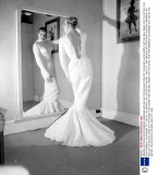 SWEDISH ACTRESS ANITA EKBERG EXAMINES HER REFLECTION AS SHE TRIES ON THE SHEATH-LIKE GOWN THAT SHE WILL WEAR FOR THE ROYAL FILM PERFORMANCE ON MONDAY OCT. 29th AT THE EMPIRE, ON LEICESTER SQUARE.  28th OCT, 1956