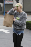 Miley Cyrus plays peek-a-boo with photographers as she leaves Earth Bar