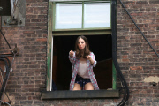 Alison Brie gets animated outside a Window for "How to Be Single"