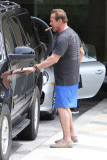 Arnold Schwarzenegger smokes a cigar while checking out a friend's new ride