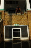 Man on porch flooded after hurricane Katrina ravishes New Orleans.