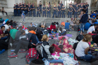 NEWS:  Flüchtlinge warten auf ein Ende der Polizeiabsperrung am Bahnhof in Budapest