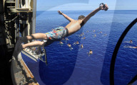 FEATURE - "Swim Call" - Matrosen hüpfen zu hunderten von ihren Navy-Schiffen