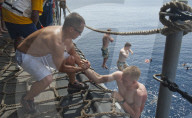 FEATURE - "Swim Call" - Matrosen hüpfen zu hunderten von ihren Navy-Schiffen