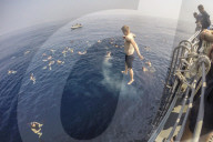 FEATURE - "Swim Call" - Matrosen hüpfen zu hunderten von ihren Navy-Schiffen
