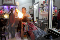 FEATURE - Heisse Sache: Barbier benutzt Feuer um die Haare zu glätten