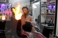 FEATURE - Heisse Sache: Barbier benutzt Feuer um die Haare zu glätten