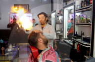 FEATURE - Heisse Sache: Barbier benutzt Feuer um die Haare zu glätten