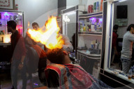FEATURE - Heisse Sache: Barbier benutzt Feuer um die Haare zu glätten