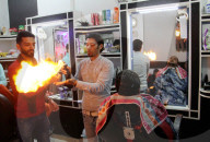 FEATURE - Heisse Sache: Barbier benutzt Feuer um die Haare zu glätten