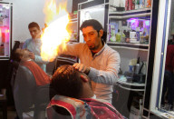 FEATURE - Heisse Sache: Barbier benutzt Feuer um die Haare zu glätten