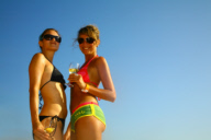 Two sexy women enjoying drinks on the beach, Ibiza 2006