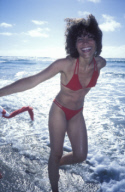 Girl in a red bikini smilling, walking on the beach, UK 2004