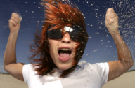 verrŸckte junge rothaarige Frau lŠ§t Sand durch die Finger rinnen, crazy young redheaded woman slipping sand through her fingers