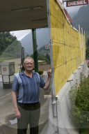 Sprengung am Gotthard, 2006: Tankwart Hans Stern vor der Schutzmauer vor seiner Tankstelle