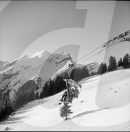 Verschneite Landschaft, Menschen fahren mit Sessellift; 1951