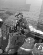 Heringfischerei in der Nordsee: Seemann dreht Zigarette 1954