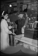 Verkäuferin bedient Kunden in Lebensmittelgeschäft; 1945