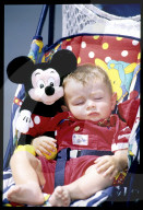 Schlafendes Kind in Kinderwagen mit Mickey Mouse