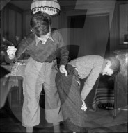 Knabe flickt seinem Bruder die Hose, 1941