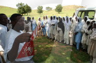 Minensucher zeigt Minenwarntafel, Dorf Sama im Sudan, 2004