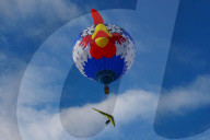 Ballon mit Deltasegler am blauen Himmel
