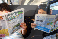 Pendler lesen Gratiszeitung  im Zug, Heute und 20 Minuten