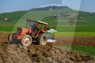 Landwirt pfluegt sein Feld im Emmental