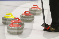 Curlingsteine und Besen