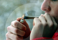 Mann zündet Joint, Cannabis Zigarette