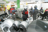 Strassenverkehr,  Motorradfahrer an einer Migrol Tankstelle.
