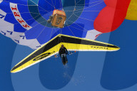 Ballon mit Deltasegler am blauen Himmel