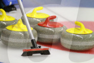 Curlingsteine und Besen