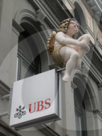 Engel sitzt auf UBS Schriftzug