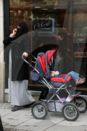 Muslimin mit Kleinkind und Handy