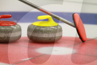 Curlingsteine und Besen
