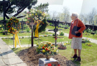 Friedhof , Rentnerin steht vor einem Grab.