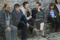 Griechen und Griechinnen sitzen auf einer Bank, 2004