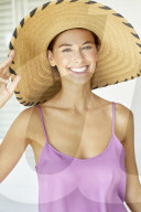 Beautiful woman playing around with straw hat