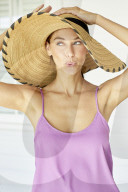 Beautiful woman playing around with straw hat