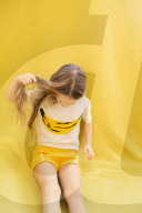 Summer Fashion: Girl looking at her T-Shirt with Banana-Print